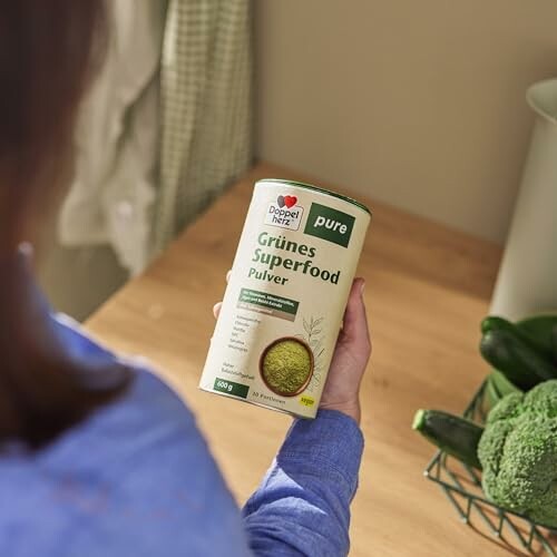 Person hält grünes Superfood-Pulver in der Hand